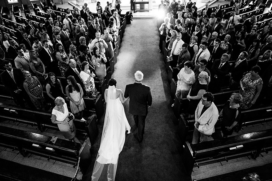 Wide photo of bride walking down the aisle with her father