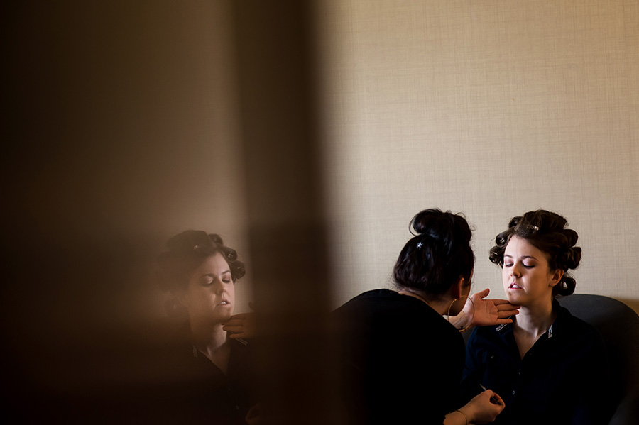 Bride getting her make-up applied with a reflection.