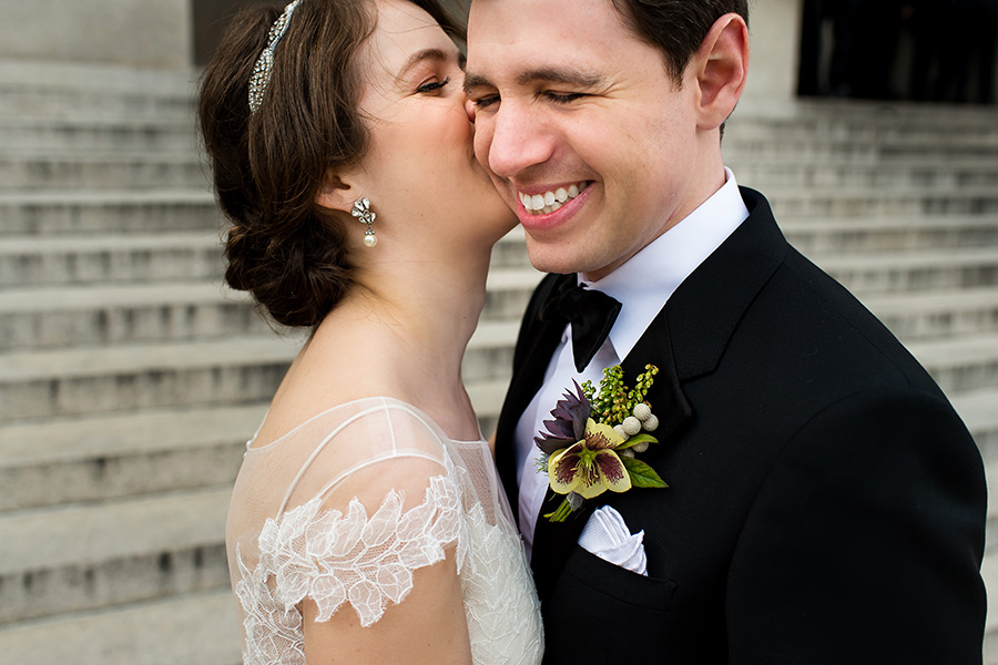 Bride kissing groom on the cheek on their wedding day.