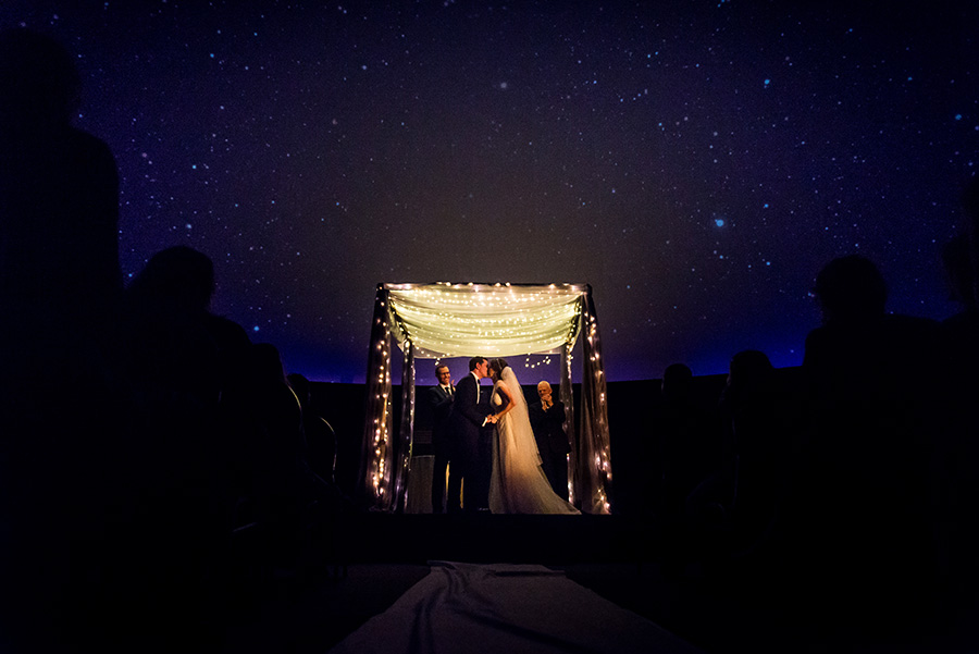 Bride and groom under stars in Planetarium at Franklin Institute.