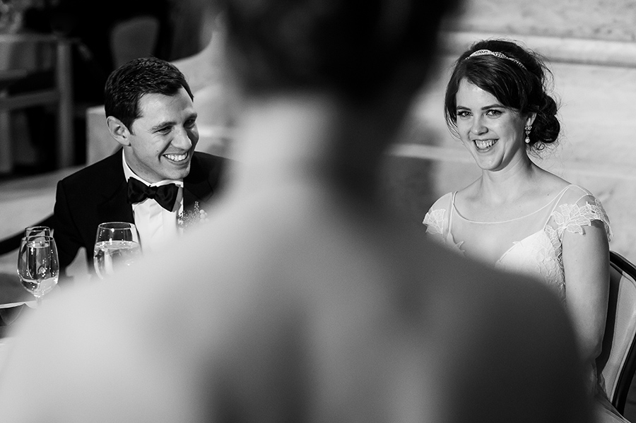 Bride and groom laugh to maid of honor speech.