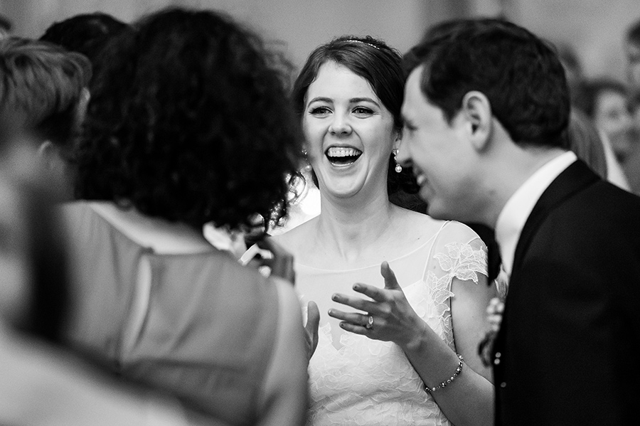 Bride laughing with guests on her wedding day.