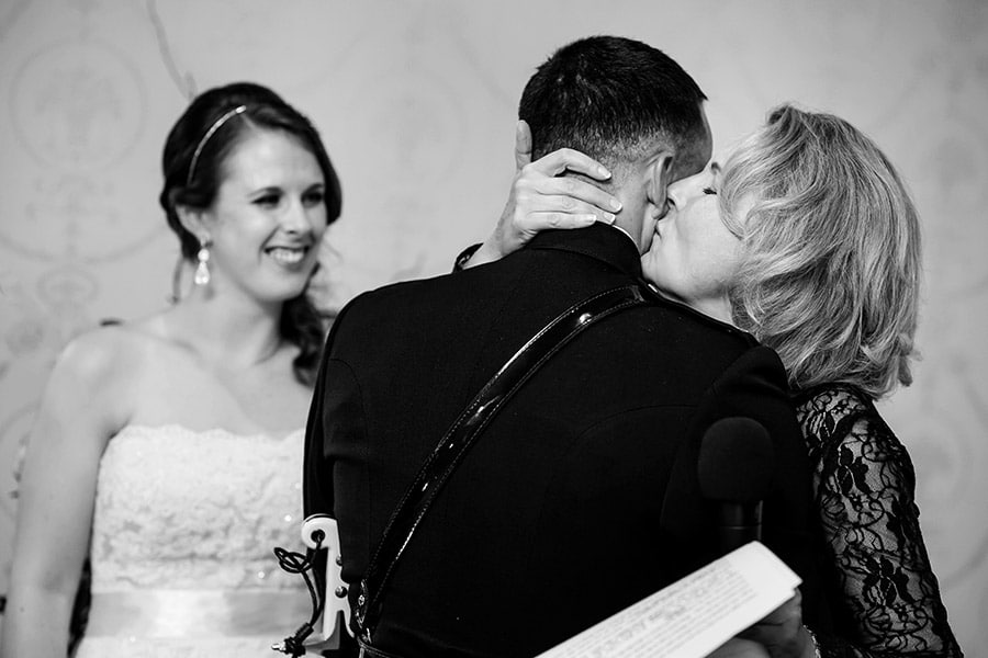 Mother of the bride kisses the groom after her speech.