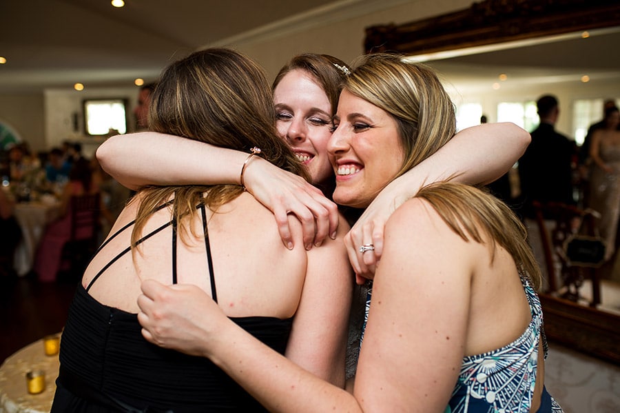 Bride hugs her friends on her wedding day.