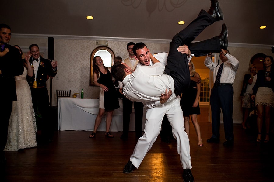 Groom dancing and carrying a wedding guests at the wedding reception.