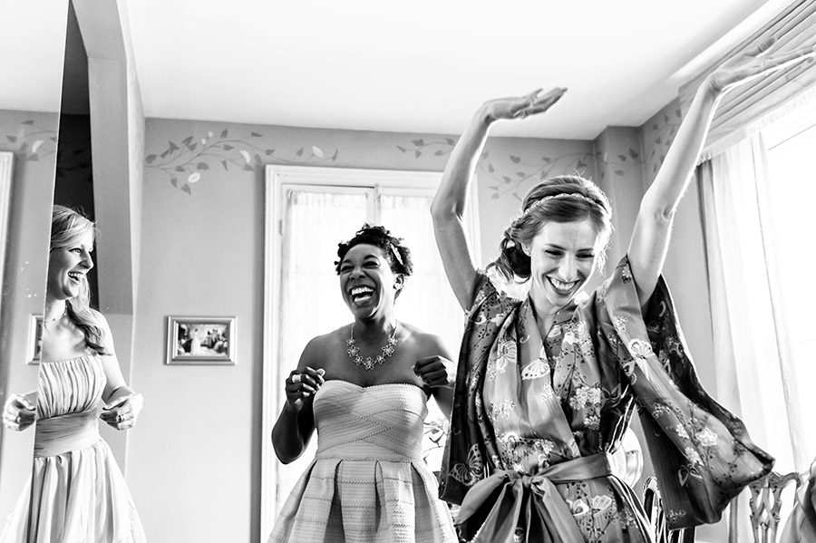 Bride and bridesmaids dancing excitedly on the wedding morning.