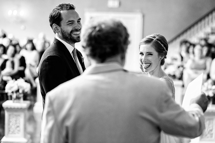 Bride and groom laughing at officiant.