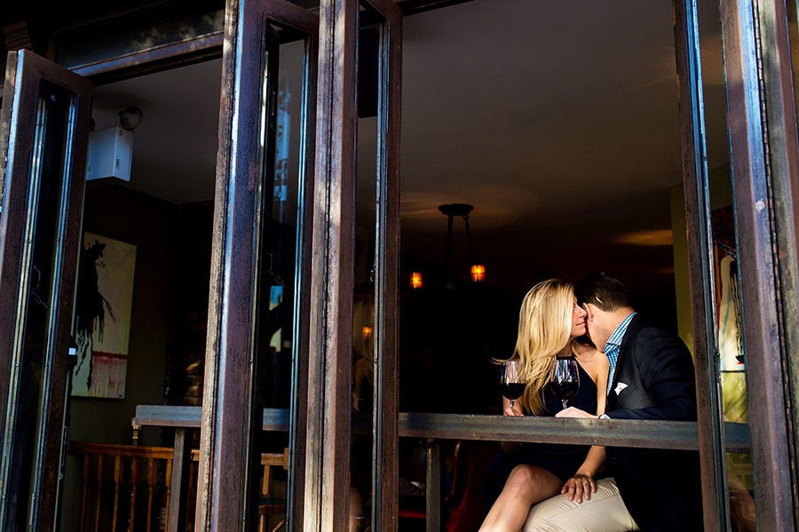 Groom-to-be kisses his bride-to-be on her shoulder in an NYC wine bar.