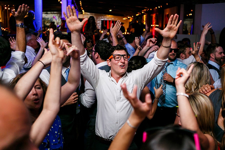 Wedding guest raises his arms like he just doesn't care.