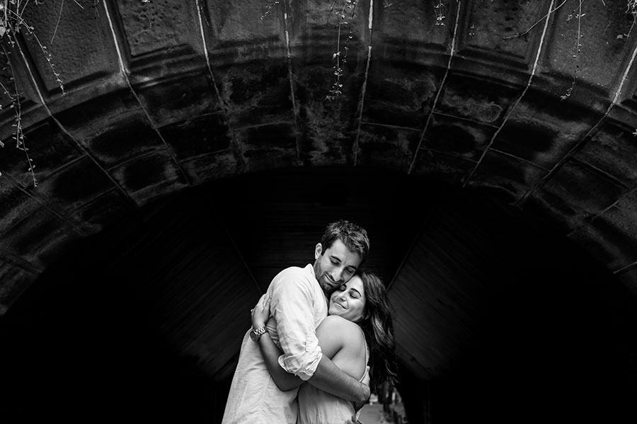 An engaged couple hug during their Central Park engagement.