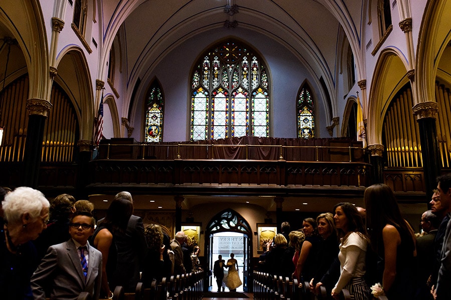 Father of the bride and bride enter the church to walk down the aisle in Philadelphia wedding ceremony.
