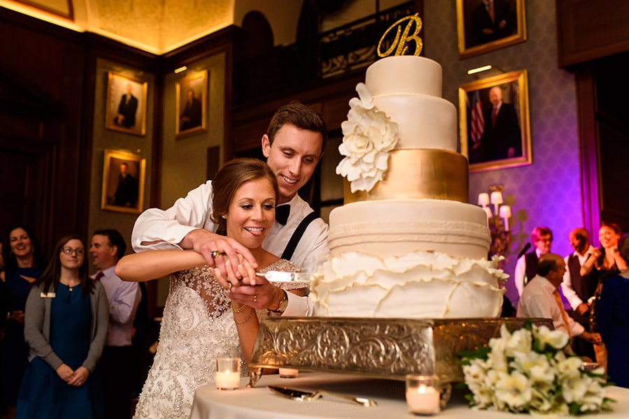 Bride and groom cut cake at wedding reception at the Union League in Philadelphia, PA.