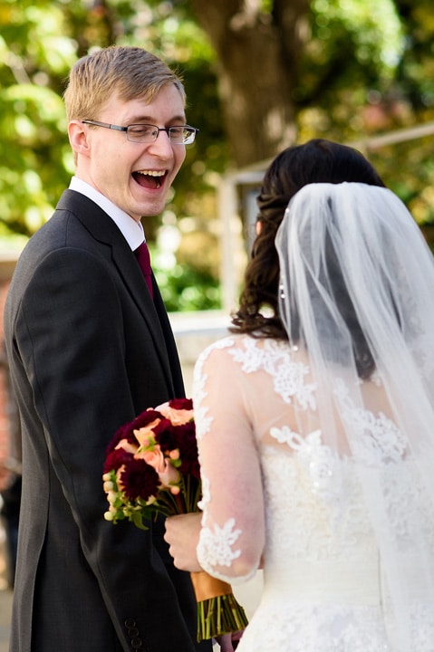 Excited groom seeing his bride for the first time at their first look.