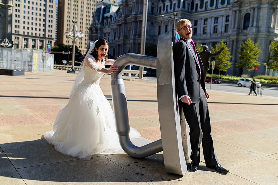 Bride ironing groom with giant Monopoly game piece in Center City Philadelphia.