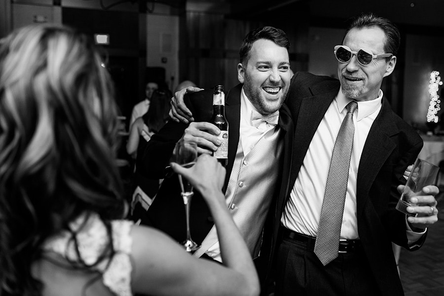 Wedding guest dances with his arm around the groom during wedding reception at Bear Creek in Macungie, PA.