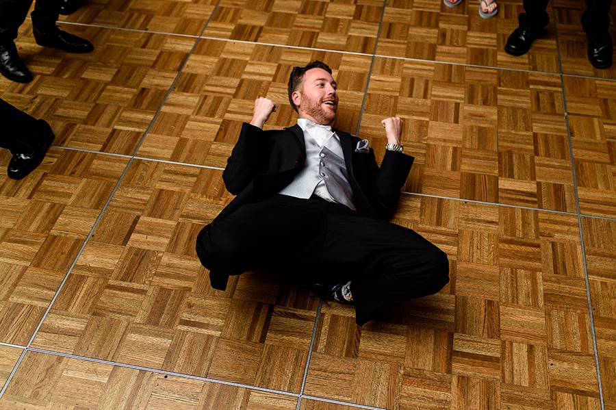 Groom dances on the floor during wedding reception.